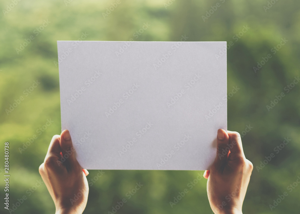 Show business paper in hand on nature background Show business paper in hand on nature background