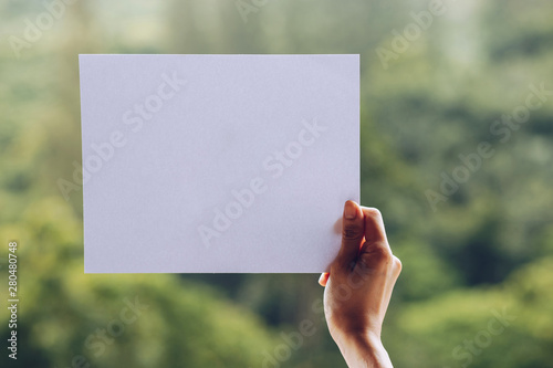 Show business paper in hand on nature background © khonkangrua