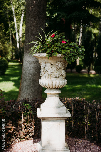 Beautiful stone vase with flowers in the park