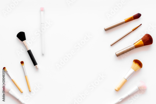 Brushes for make up on white visagiste work desk background top view copyspace photo