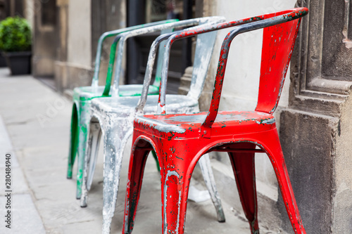 Photos Three empty rickety colorful chairs at the historical streets of Florence