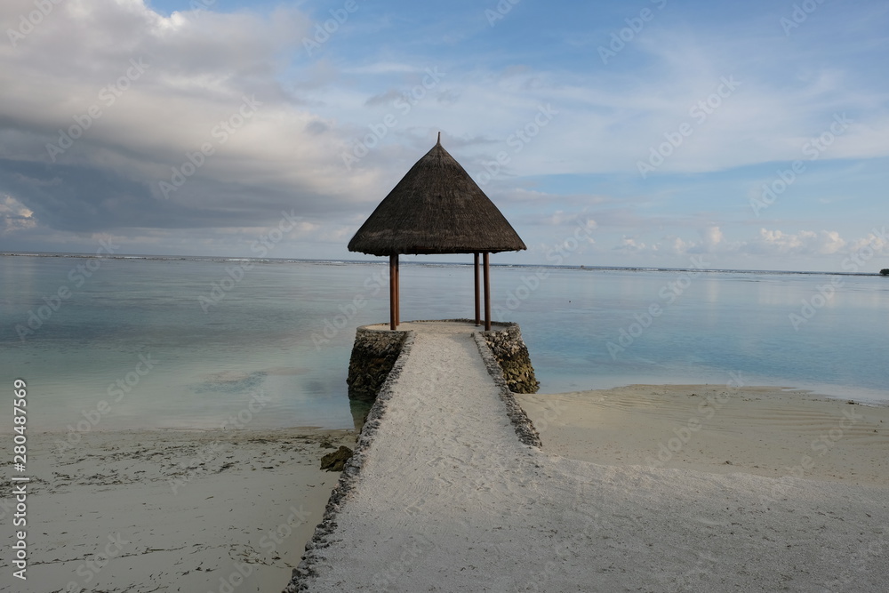 outdoor wooden brown pavilion on white sand beach in Maldive island resort. Magnificent white cloud skyline. Peaceful blue sea horizon