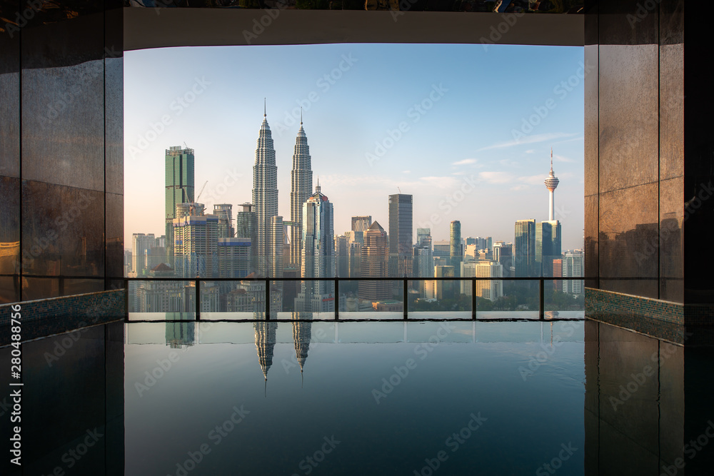 Fototapeta premium Swimming pool on roof top with beautiful city view in morning at Kuala lumpur, Malaysia. Travel and Vacation concept.