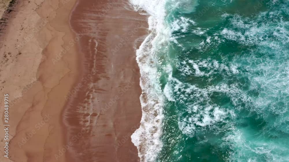 Waves crash onto a pristine beach. Blue ocean. Waves crash onto a pristine beach. Blue ocean.