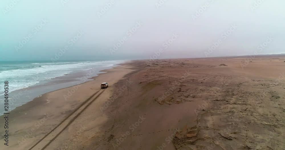 Arial birds eye view of the magnificent Namibian Skeleton Coast. Driving on the beach. The unforgiving Atlantic Ocean Waves crashes onto the shore, where many ships have lost the war.