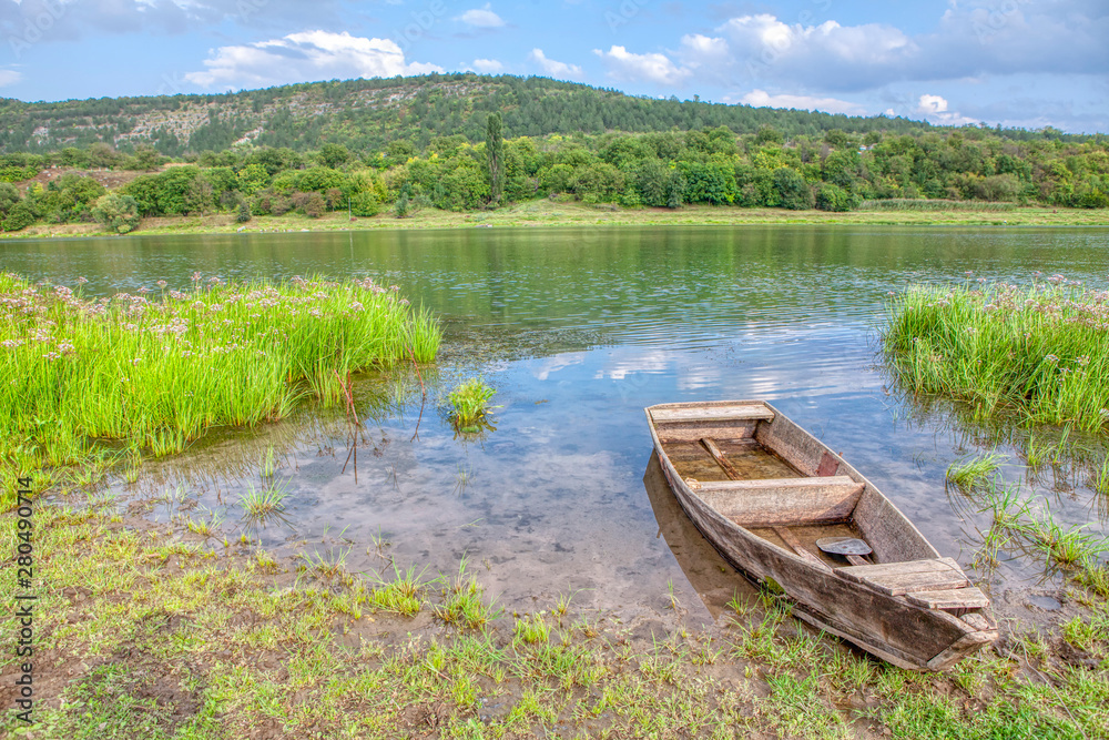 Old wooden fishing boat on the river shore Old wooden fishing boat on the river shore