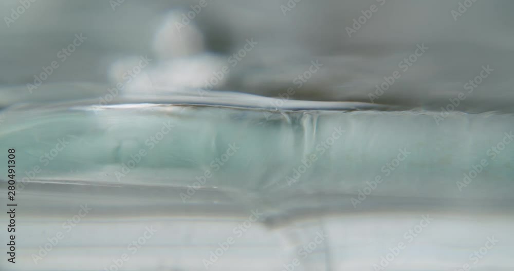 detail sideview of a transparent viscous gel, which slightly moves in the blurry background. in the foreground small air bubbles are visible. art animation experimental footage detail sideview of a transparent viscous gel, which slightly moves in the blurry background. in the foreground small air bubbles are visible. art animation experimental footage