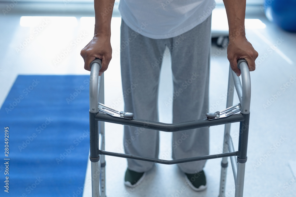 Male patient walking with walker in the ward at hospital Male patient walking with walker in the ward at hospital