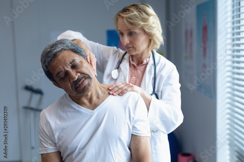 Wallpaper Mural Female doctor examining male patient neck in hospital Torontodigital.ca