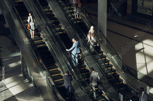Business people using escalators in modern office  photo