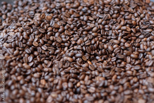 close up a pile of fresh bright roasted coffee beans under sunlight. Soft focus background