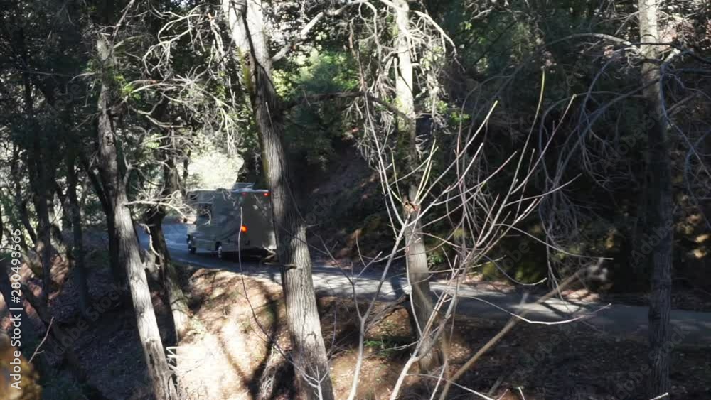 Class C RV motorhome driving through oak tree forest along the Nacimiento Fergusson Road in California. Class C RV motorhome driving through oak tree forest along the Nacimiento Fergusson Road in California.