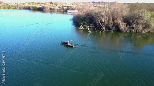 Aerial shot of a kayaker paddling across  a beautiful blue lake in Yuma, Arizona photo