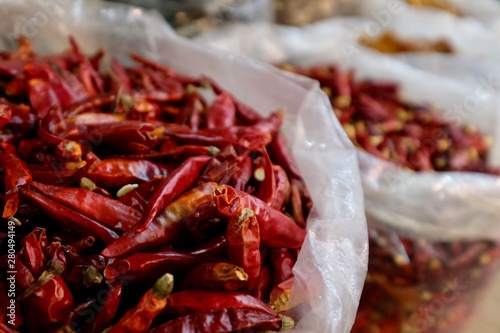 Close up a heap of dry red peppers ( dried chili ) in plastic bag in grocery market. Blur background