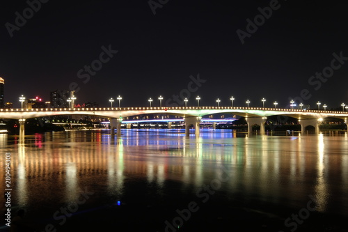 Long exposure of Yongjiang bridge in Nanning city Guangxi province China at night. Double cantilever reinforced concrete and Double column pier bridge. Yellow reflection on river surface
