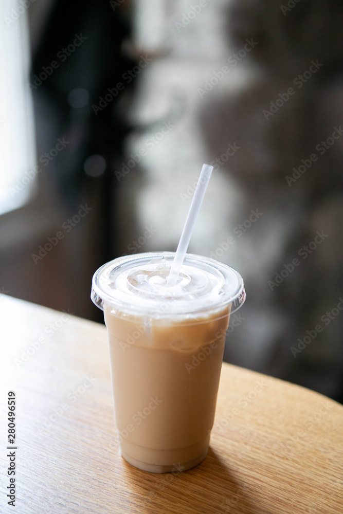 Iced Chai Latte in To Go Cup on Table, Coffee on Wooden Bar in Cafe, Close up photo Iced Chai Latte in To Go Cup on Table, Coffee on Wooden Bar in Cafe, Close up photo
