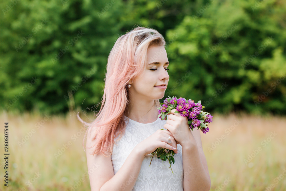 Portrait of a beautiful young woman with pink hair and a clover bouquet, close-up