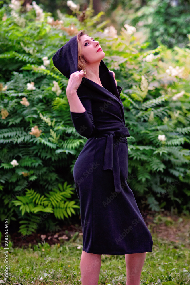 young girl in a black dress walks in a summer park young girl in a black dress walks in a summer park