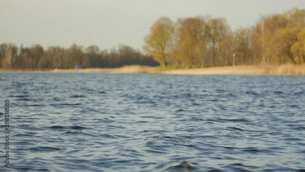 Beautiful landscape with the peaceful water surface, forest trees in the background. Low angle shot. Beautiful landscape with the peaceful water surface, forest trees in the background. Low angle shot.