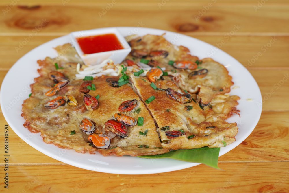 Fried noodle Thai style on a white plate on a brown table Fried noodle Thai style on a white plate on a brown table