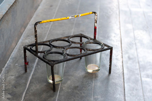 Two empty masala tea glasses in old metal glass holder