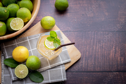 wood table with freshly squeezed lemon juice with mint and sliced lemon.