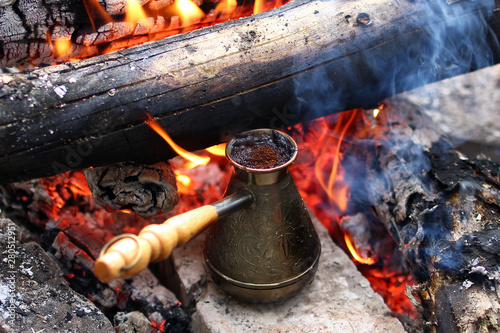 Metal cezve with hot coffee on a bonfire.