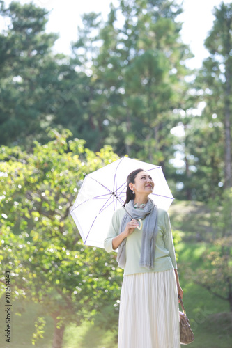 日傘をさす笑顔の中年女性