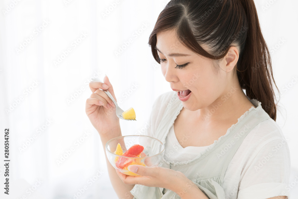 カットフルーツを食べる女性 カットフルーツを食べる女性
