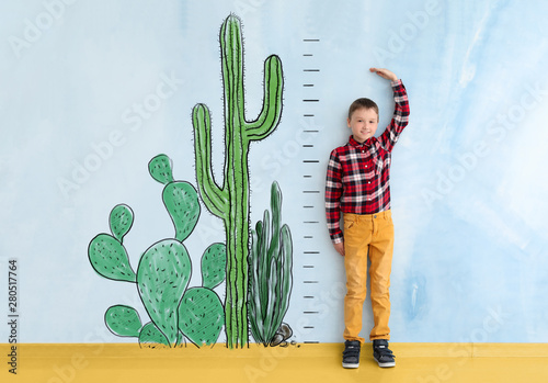 Cute little boy measuring h...
