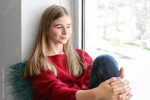 Cute teenage girl sitting o...