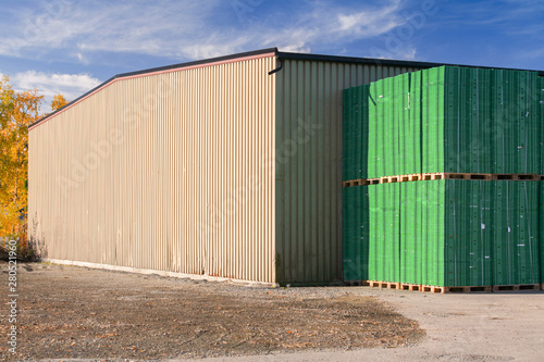 Storage building and stacks of green pallets © evannovostro