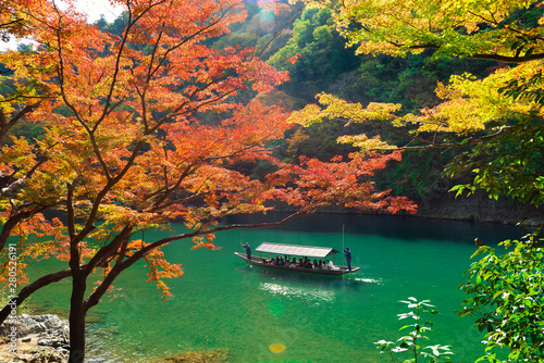 beautiful scene with tourist boat and Hozugawa river in Arashiyama park in autumn season, Kyoto, Japan