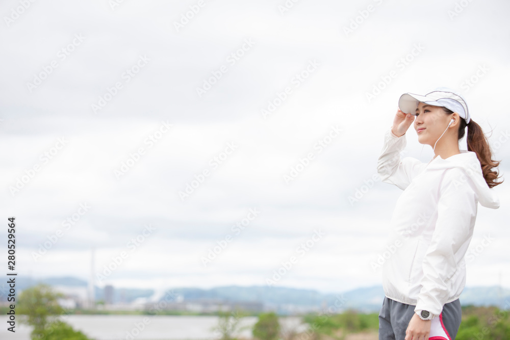 遠くを見るジョギングウェアの女性