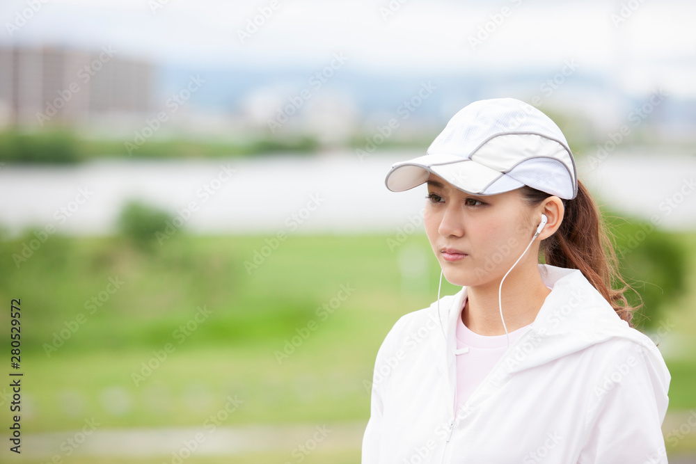 遠くを見るジョギングウェアの女性