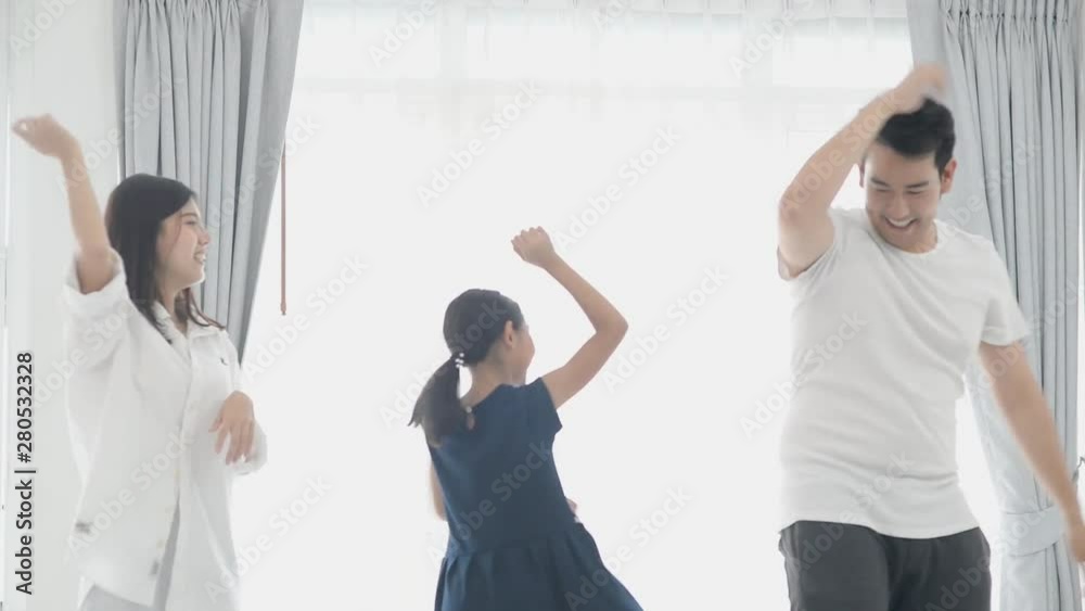 Happy young Asian family dancing together at home. Happy young Asian family dancing together at home.