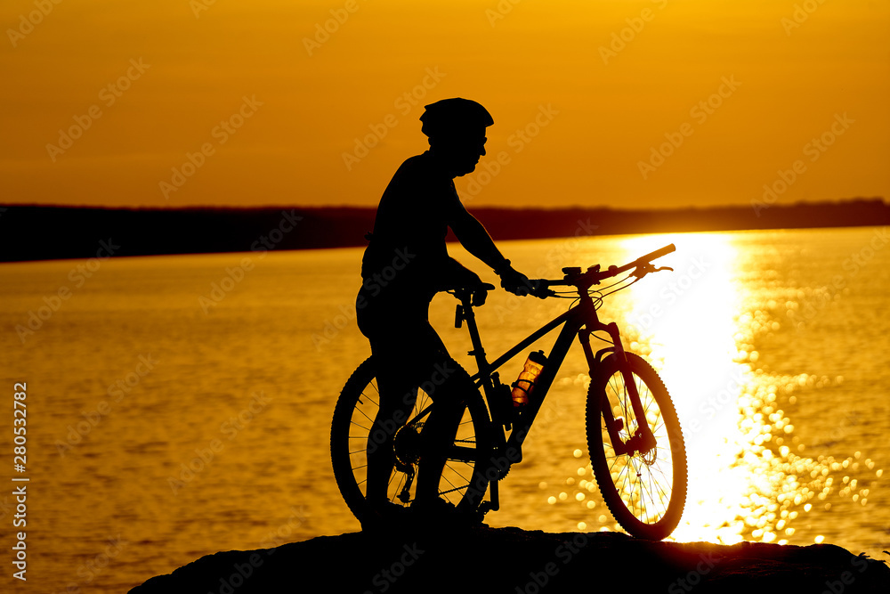 Fototapeta premium Man cycling at beach on twilight summer season. Active Lifestyle Concept.