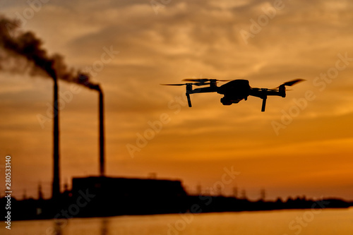 drone silhouette against the background of the sunset. Flying drone in the evening sky.