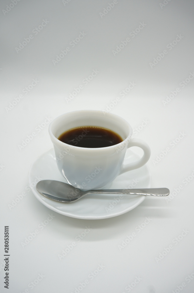 White cup of coffee with spoon on white background