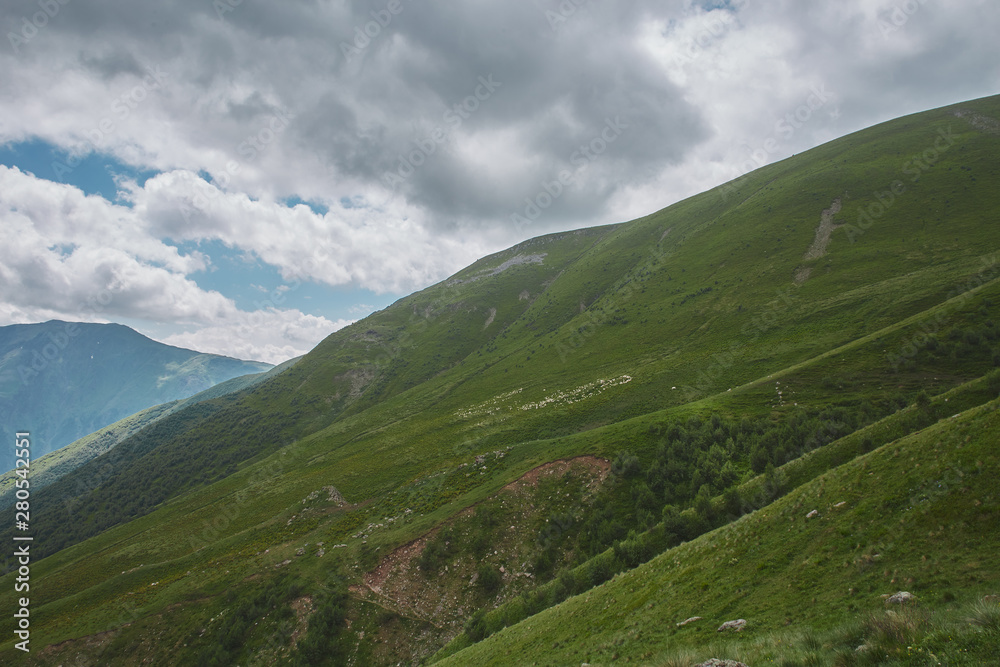 Large scenery of rocky mountains and green hills. many sheeps. Kazbegi Georgia Large scenery of rocky mountains and green hills. many sheeps. Kazbegi Georgia
