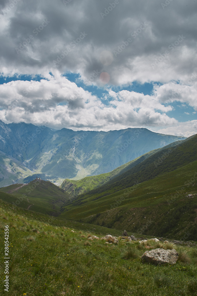 Fototapeta premium Large scenery of rocky mountains and green hills. Kazbegi Georgia