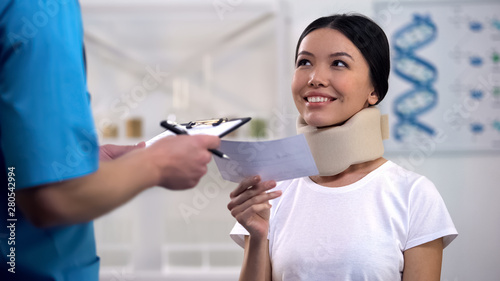 Doctor giving prescription to happy woman in foam cervical collar cheap medicine