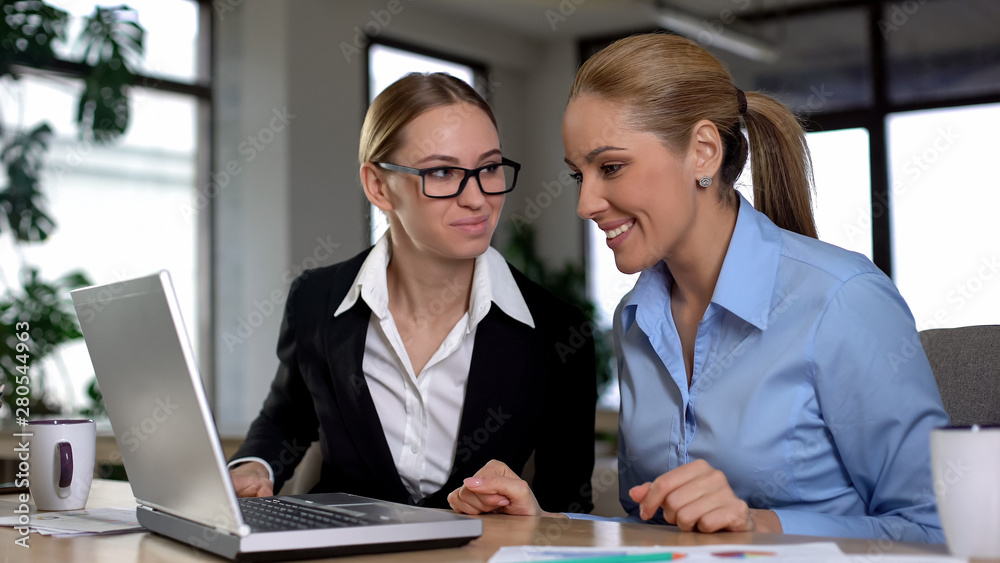 Two female workers reading email about promotion, happy for each other, support Two female workers reading email about promotion, happy for each other, support