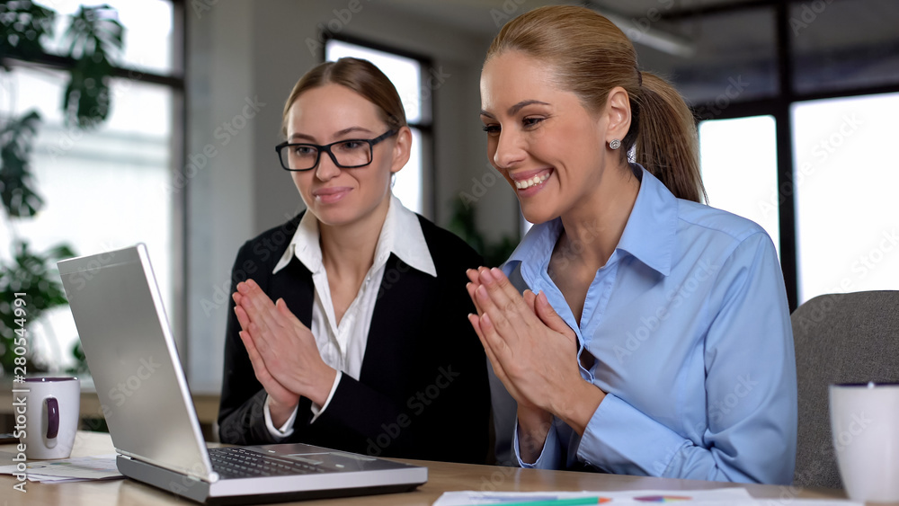 Two female entrepreneurs excited with great news on laptop, rejoicing profits Two female entrepreneurs excited with great news on laptop, rejoicing profits