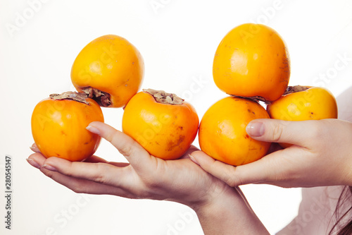 Hand holding persimmon kaki fruits