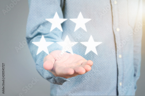 Hand touching five star symbol to increase rating
