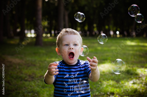 little boy blowing soap bubbles