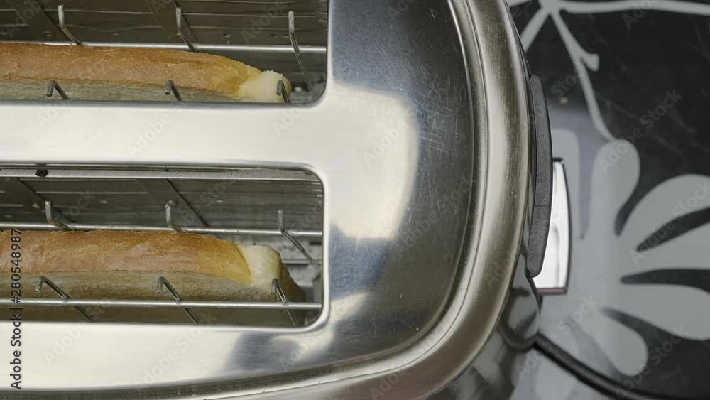 closeup of bread falling into toaster when hand presses lever. closeup of bread falling into toaster when hand presses lever.