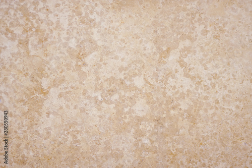 Smooth spotted texture depicting the stone surface of beige limestone tuff, serving as a background.