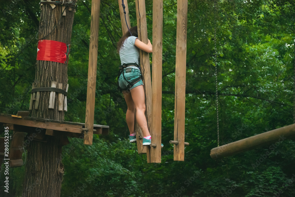 Rope park. Obstacle course. beautiful girl goes in for sports Rope park. Obstacle course. beautiful girl goes in for sports